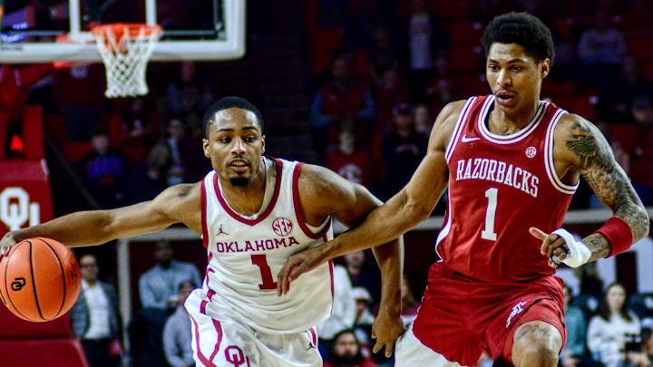 Oklahoma guard Xzayvier Brown dribbles against Arkansas' Meleek Thomas.