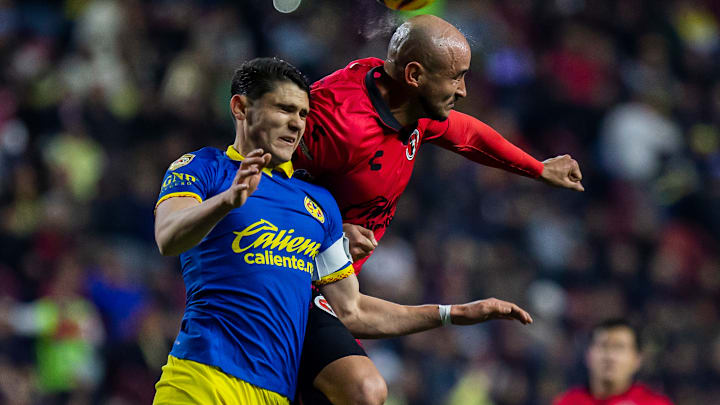 Israel Reyes del América y el paraguayo Carlos González de Tijuana luchan en el aire por el esférico