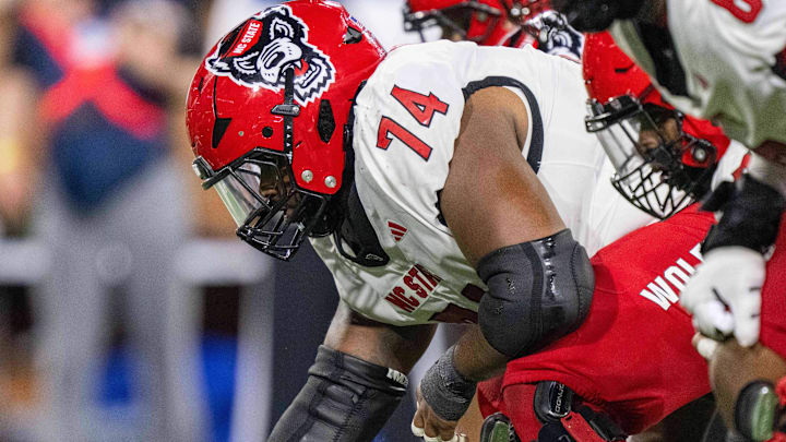 Sep 11, 2025; Winston-Salem, North Carolina, USA;  North Carolina State Wolfpack offensive lineman Jalen Grant (74) snaps the ball against the Wake Forest Demon Deacons in the second half at Allegacy Federal Credit Union Stadium. Mandatory Credit: Luke Jamroz-Imagn Images