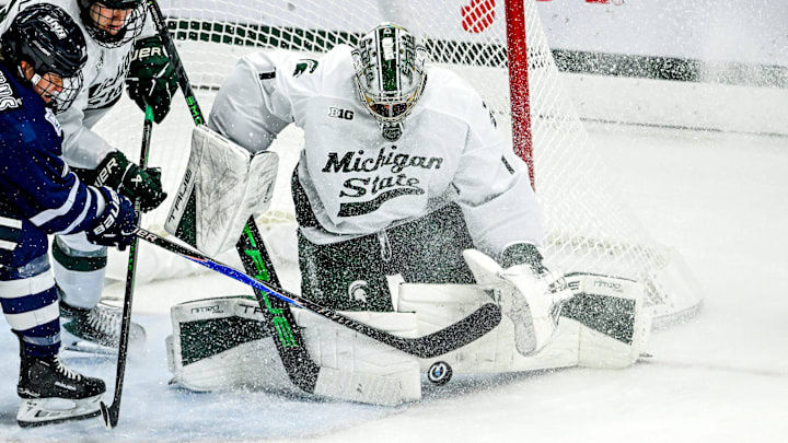 Michigan State's Trey Augustine blocks the goal from New Hampshire's Kristaps Skrastins, left, during the second period on Thursday, Oct. 9, 2025, at Munn Ice Arena in East Lansing. Michigan State's Trey Augustine blocks the goal from New Hampshire's Kristaps Skrastins, left, during the second period on Thursday, Oct. 9, 2025, at Munn Ice Arena in East Lansing.