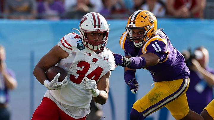 Jan 1, 2024; Tampa, FL, USA;  Wisconsin Badgers running back Jackson Acker (34) runs with the ball against the LSU Tigers in the fourth quarter during the ReliaQuest Bowl at Raymond James Stadium. Mandatory Credit: Nathan Ray Seebeck-Imagn Images
