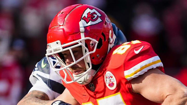 Dec 24, 2022; Kansas City, Missouri, USA; Kansas City Chiefs tight end Travis Kelce (87) carries the ball against Seattle Seahawks safety Teez Tabor (39) during the first half at GEHA Field at Arrowhead Stadium. Mandatory Credit: Jay Biggerstaff-Imagn Images