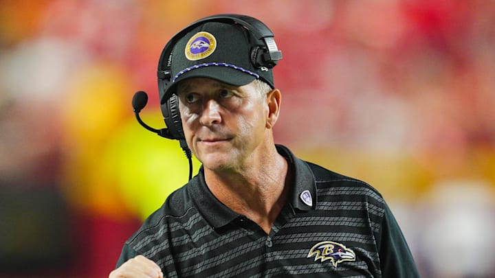 Baltimore Ravens head coach John Harbaugh talks with quarterback Lamar Jackson.