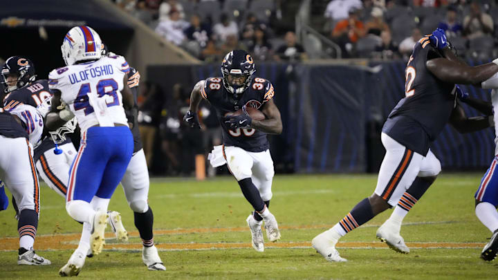 Brittain Brown breaks to a hole created by Bears lineman Kiran Amegadjie (right) during a second half play Sunday.