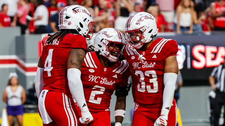 Aug 28, 2025; Raleigh, North Carolina, USA; North Carolina State Wolfpack safety Ronnie Royal III (2),  linebacker Tra Thomas (4) and  linebacker Kenny Soares Jr. (33) celebrate during the first half of the game against East Carolina Pirates at Carter-Finley Stadium. Mandatory Credit: Jaylynn Nash-Imagn Images