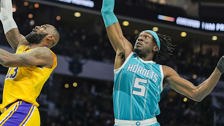 Los Angeles Lakers forward LeBron James makes a layup past Charlotte Hornets center Mark Williams.
