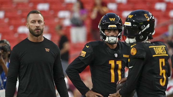 Aug 25, 2024; Landover, Maryland, USA; Washington Commanders offensive coordinator Kill Kingsbury watches Washington Commanders quarterback Jayden Daniels (5) warm up before the game against the New England Patriots  at Commanders Field. Mandatory Credit: Tommy Gilligan-Imagn Images
