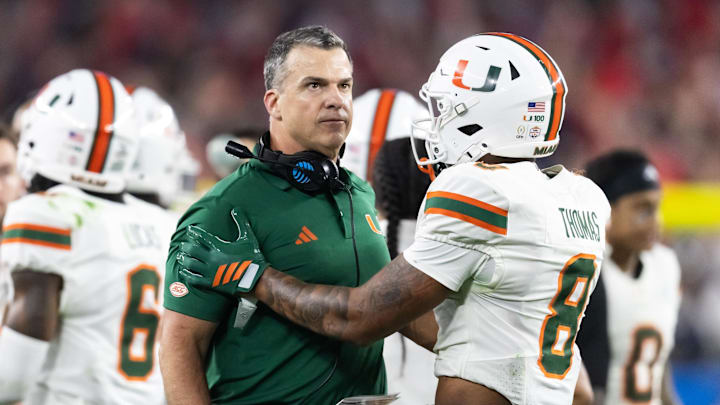 Jan 8, 2026; Glendale, AZ, USA; Miami Hurricanes head coach Mario Cristobal with defensive back Jakobe Thomas (8) against the Mississippi Rebels during the 2026 Fiesta Bowl and semifinal game of the College Football Playoff at State Farm Stadium. Mandatory Credit: Mark J. Rebilas-Imagn Images