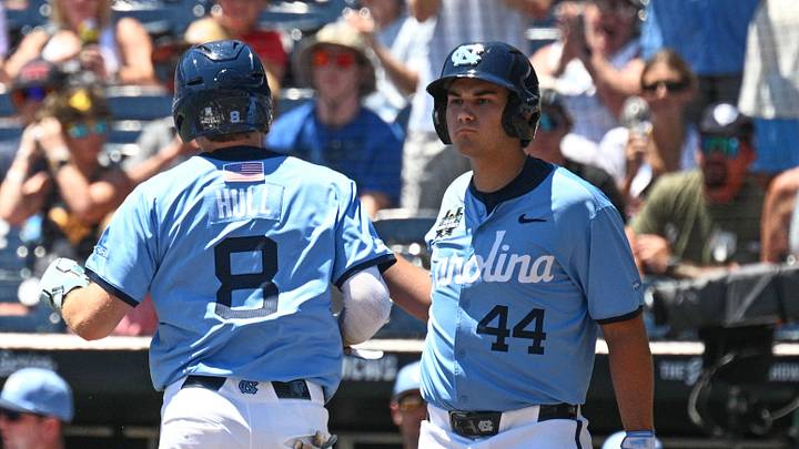 Jun 17, 2026; Omaha, NE, USA; North Carolina Tar Heels center fielder Owen Hull (8) scores on an overthrow as West Virginia Mountaineers catcher Matthew Graveline (0) looks on during the first inning at Charles Schwab Field. Mandatory Credit: Steven Branscombe-Imagn Images Jun 17, 2026; Omaha, NE, USA; North Carolina Tar Heels center fielder Owen Hull (8) scores on an overthrow as West Virginia Mountaineers catcher Matthew Graveline (0) looks on during the first inning at Charles Schwab Field. Mandatory Credit: Steven Branscombe-Imagn Images