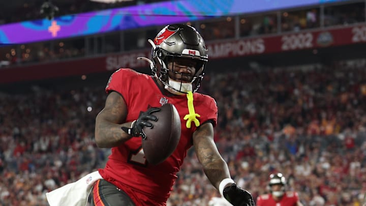 Jan 12, 2025; Tampa, Florida, USA; Tampa Bay Buccaneers running back Bucky Irving (7) makes a touchdown catch against Washington Commanders linebacker Frankie Luvu (4) during the third quarter of a NFC wild card playoff at Raymond James Stadium. Mandatory Credit: Nathan Ray Seebeck-Imagn Images