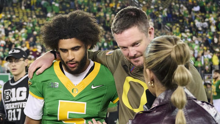 Nov 14, 2025; Eugene, Oregon, USA; Oregon Ducks quarterback Dante Moore (5) and head coach Dan Lanning talk to a reporter after a game against the Minnesota Golden Gophers at Autzen Stadium. Mandatory Credit: Troy Wayrynen-Imagn Images