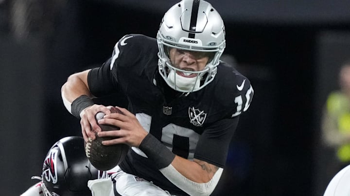 Dec 16, 2024; Paradise, Nevada, USA; Las Vegas Raiders quarterback Desmond Ridder (10) carries the ball against Atlanta Falcons linebacker Arnold Ebiketie (17) in the first half at Allegiant Stadium. Mandatory Credit: Kirby Lee-Imagn Images