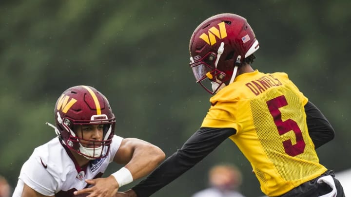 Washington Commanders quarterback Jayden Daniels (5) hands the ball to running back Austin Ekeler during OTA practice in Ashburn, Virginia. Washington Commanders quarterback Jayden Daniels (5) hands the ball to running back Austin Ekeler during OTA practice in Ashburn, Virginia.