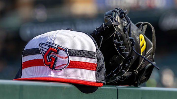 Jul 8, 2024; Detroit, Michigan, USA; A Cleveland Guardians baseball cap and glove sit on the dugout rail before the game against the Detroit Tigers at Comerica Park. Mandatory Credit: David Reginek-Imagn Images