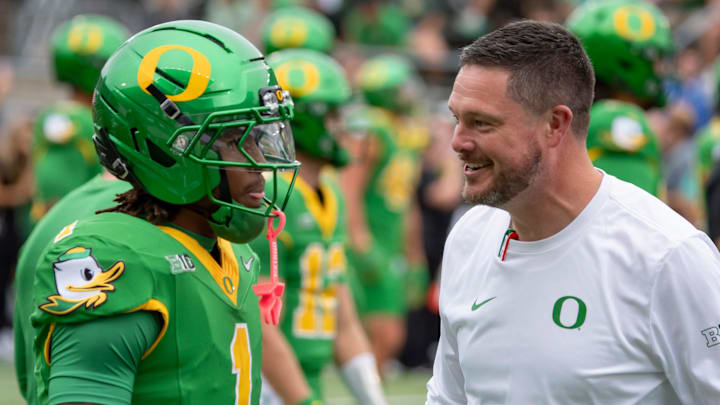 Oregon head coach Dan Lanning  talks with Oregon wide receiver Dakorien Moore during warmups as the Oregon Ducks host the Oklahoma State Cowboys at Autzen Stadium.