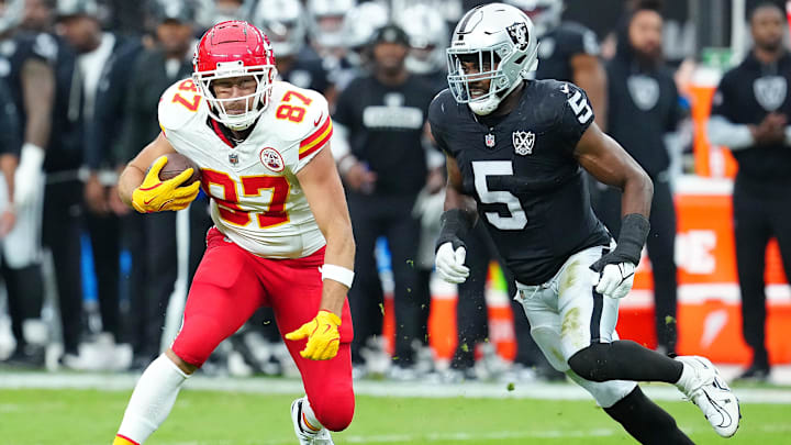 Oct 27, 2024; Paradise, Nevada, USA; Kansas City Chiefs tight end Travis Kelce (87) looks to evade the tackle of Las Vegas Raiders linebacker Divine Deablo (5) during the first quarter at Allegiant Stadium. Mandatory Credit: Stephen R. Sylvanie-Imagn Images