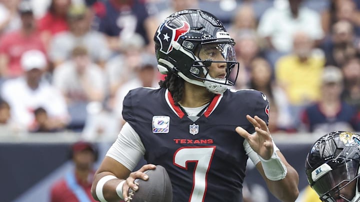 Sep 29, 2024; Houston, Texas, USA; Houston Texans quarterback C.J. Stroud (7) looks for an open receiver as Jacksonville Jaguars defensive end Josh Hines-Allen (41) applies defensive pressure during the second quarter at NRG Stadium. Mandatory Credit: Troy Taormina-Imagn Images