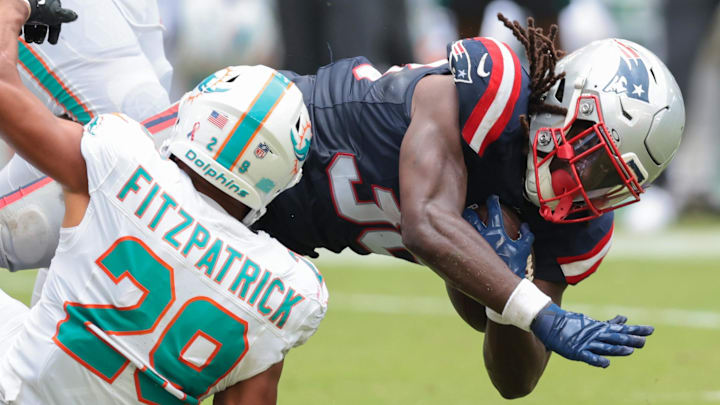 New England Patriots running back Rhamondre Stevenson carries the football against Miami Dolphins safety Minkah Fitzpatrick