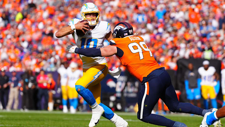 Oct 13, 2024; Denver, Colorado, USA; Denver Broncos defensive end Zach Allen (99) reaches for Los Angeles Chargers quarterback Justin Herbert (10) in the second quarter at Empower Field at Mile High. 