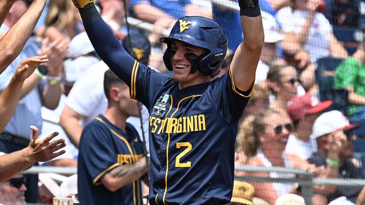 Jun 16, 2026; Omaha, NE, USA;  West Virginia Mountaineers second baseman Gavin Kelly (2) reacts with teammate after scoring against the Troy Trojans during the second inning at Charles Schwab Field. Mandatory Credit: Steven Branscombe-Imagn Images