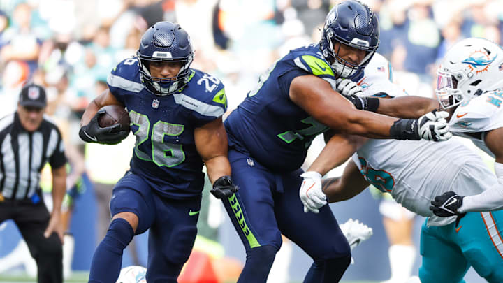 Sep 22, 2024; Seattle, Washington, USA; Seattle Seahawks running back Zach Charbonnet (26) rushes behind a block by offensive tackle Stone Forsythe (78) against the Miami Dolphins during the fourth quarter at Lumen Field. Mandatory Credit: Joe Nicholson-Imagn Images