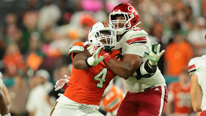 Oct 17, 2025; Miami Gardens, Florida, USA; Miami Hurricanes defensive lineman Rueben Bain Jr. (4) attempts to pressure Louisville Cardinals quarterback Miller Moss (7) as offensive lineman Rasheed Miller (60) defends during the fourth quarter at Hard Rock Stadium. Mandatory Credit: Sam Navarro-Imagn Images