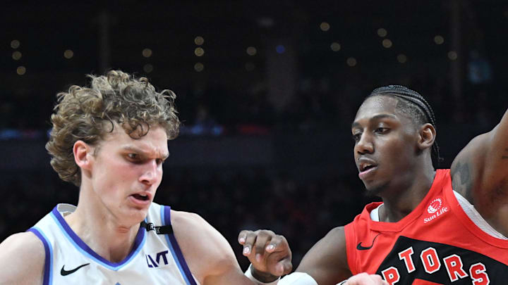 Utah Jazz forward Lauri Markkanen dribbles the ball as Toronto Raptors forward RJ Barrett defends.