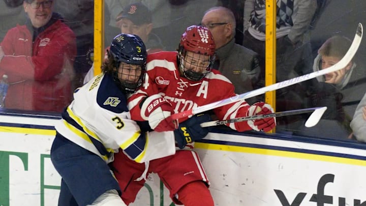 Merrimack freshman Filip Nordberg and Boston University sophomore Cole Hutson battle for a loose puck.