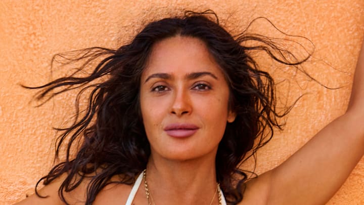 Salma Hayek Pinault was photographed by Ruven Afanador in Mexico. Swimsuit by TJ Swim. Necklace by Foundrae. Body chain by Isa Grutman. Belly chain by Saint Laurent.