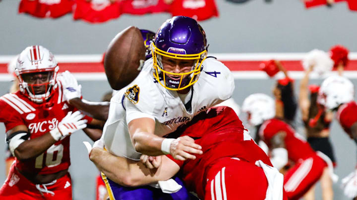Aug 28, 2025; Raleigh, North Carolina, USA; East Carolina Pirates quarterback Katin Houser (4) passes the ball to running back Marlon Gunn Jr. (21) during the second half of the game against North Carolina State Wolfpack at Carter-Finley Stadium. Mandatory Credit: Jaylynn Nash-Imagn Images Aug 28, 2025; Raleigh, North Carolina, USA; East Carolina Pirates quarterback Katin Houser (4) passes the ball to running back Marlon Gunn Jr. (21) during the second half of the game against North Carolina State Wolfpack at Carter-Finley Stadium. Mandatory Credit: Jaylynn Nash-Imagn Images