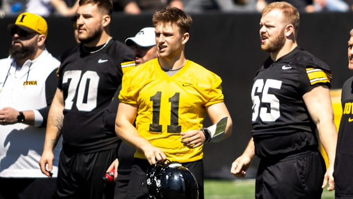 Apr 26, 2025; Iowa City, IA, USA; Iowa offensive lineman Beau Stephens (70) quarterback Mark Gronowski (11) and offensive lineman Logan Jones (65) stand with Iowa head coach Kirk Ferentz during a spring NCAA football open practice at Kinnick Stadium. Mandatory Credit: Joseph Cress/For the Register