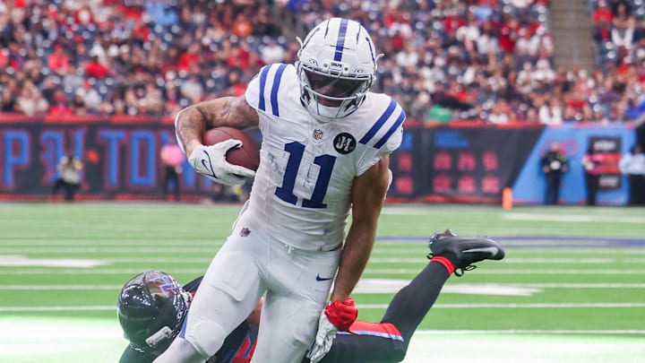 Jan 4, 2026; Houston, Texas, USA; Indianapolis Colts wide receiver Michael Pittman Jr. (11) breaks Houston Texans cornerback Alijah Huzzie (36) tackle and dives for the end zone in the second half half at NRG Stadium. Mandatory Credit: Thomas Shea-Imagn Images