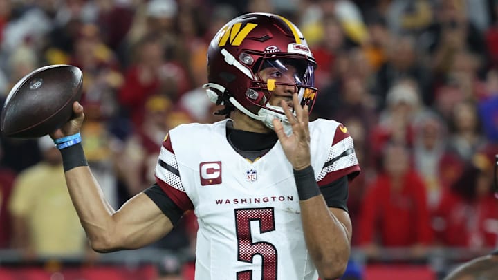 Jan 12, 2025; Tampa, Florida, USA; Washington Commanders quarterback Jayden Daniels (5) throws during the second quarter of a NFC wild card playoff against the Tampa Bay Buccaneers at Raymond James Stadium. Mandatory Credit: Kim Klement Neitzel-Imagn Images