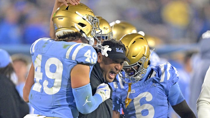 Nov 8, 2024; Pasadena, California, USA;   UCLA Bruins defensive coordinator Ikaika Malloe, center, celebrates with linebacker Carson Schwesinger (49) defensive back Jaylin Davies (6) after an interception in the second half against the Iowa Hawkeyes at the Rose Bowl. Mandatory Credit: Jayne Kamin-Oncea-Imagn Images
