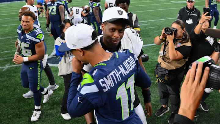 Aug 7, 2025; Seattle, Washington, USA; Las Vegas Raiders quarterback Geno Smith (7) and Seattle Seahawks wide receiver Jaxon Smith-Njigba (11) hug after the game at Lumen Field.