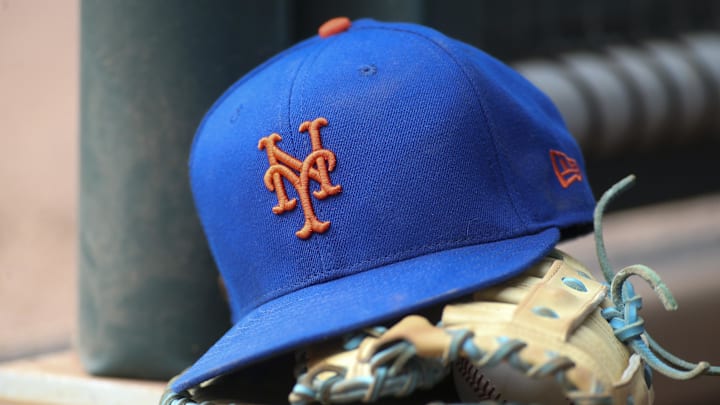 Jul 13, 2022; Atlanta, Georgia, USA; A detailed view of a New York Mets hat and glove in the dugout against the Atlanta Braves in the eighth inning at Truist Park. Mandatory Credit: Brett Davis-Imagn Images