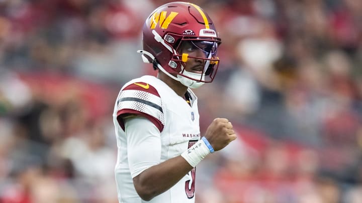 Sep 29, 2024; Glendale, Arizona, USA; Washington Commanders quarterback Jayden Daniels (5) celebrates with a fist pump against the Arizona Cardinals at State Farm Stadium. Mandatory Credit: Mark J. Rebilas-Imagn Images