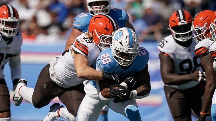 Tennessee Titans running back Tony Pollard is tackled by Cleveland Browns linebacker Carson Schwesinger.