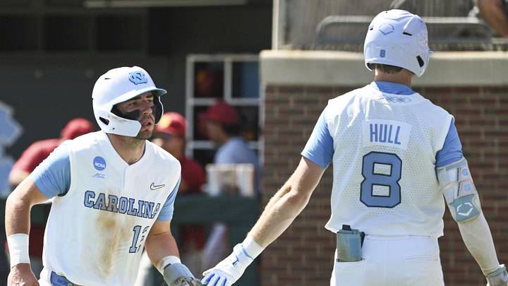 Jun 5, 2026; Chapel Hill, NC, USA;  North Carolina Tar Heels outfielder/first baseman Tyler Howe (12) celebrates with outfielder Owen Hull (8) after scoring a run against the USC Trojans head coach Andy Stankiewicz during the second inning at Boshamer Stadium. Mandatory Credit: Zachary Taft-Imagn Images