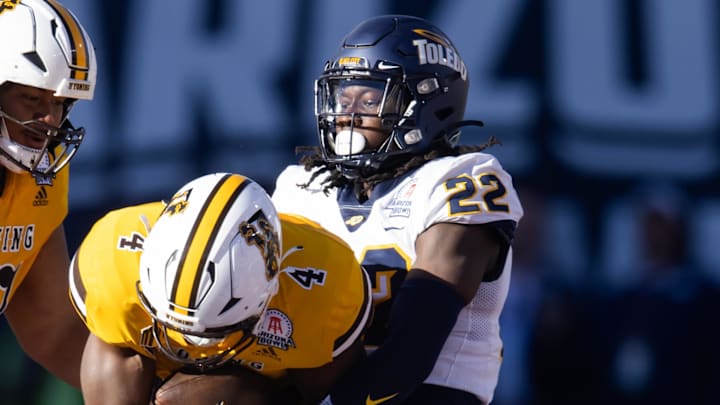 Dec 30, 2023; Tucson, AZ, USA; Toledo Rockets safety Emmanuel McNeil-Warren (22) tackles Wyoming Cowboys running back Harrison Waylee (4) in the Arizona Bowl at Arizona Stadium. Mandatory Credit: Mark J. Rebilas-USA TODAY Sports