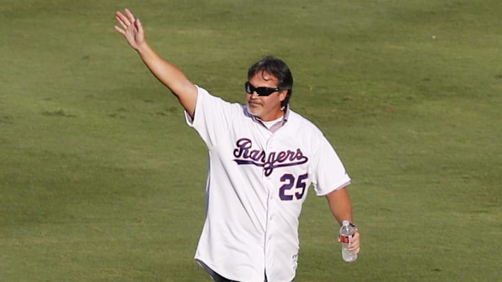 Texas Rangers former player Rafael Palmeiro waves to fans while wearing his jersey