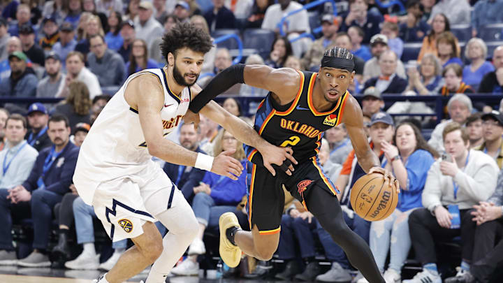 Mar 9, 2025; Oklahoma City, Oklahoma, USA; Oklahoma City Thunder guard Shai Gilgeous-Alexander (2) drives around Denver Nuggets guard Jamal Murray (27) during the second half at Paycom Center. Mandatory Credit: Alonzo Adams-Imagn Images