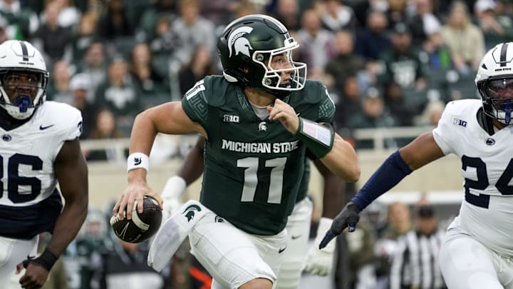 Nov 15, 2025; East Lansing, Michigan, USA; Michigan State Spartans quarterback Alessio Milivojevic (11) runs out of the pocket as Penn State Nittany Lions linebacker Amare Campbell (24) and defensive end Zuriah Fisher (36) chase in the first quarter at Spartan Stadium.