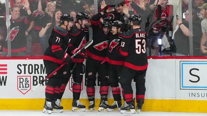 Apr 18, 2026; Raleigh, North Carolina, USA; Carolina Hurricanes left wing Taylor Hall (71) is congratulated by defenseman Alexander Nikishin (21)  defenseman Shayne Gostisbehere (4) center Logan Stankoven (22) and right wing Jackson Blake (53) after his goal against the Ottawa Senators during the third period in game one of the first round of the 2026 Stanley Cup Playoffs at Lenovo Center. Mandatory Credit: James Guillory-Imagn Images