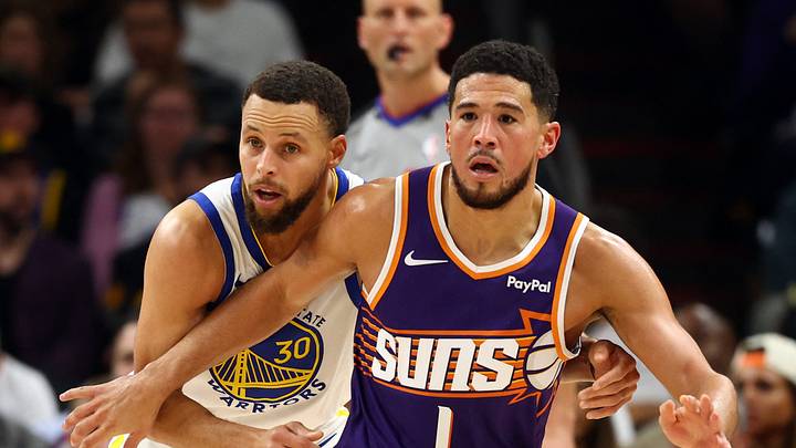 Dec 18, 2025; Phoenix, Arizona, USA; Phoenix Suns guard Devin Booker (1) against Golden State Warriors guard Stephen Curry (30) in the first half at Mortgage Matchup Center. Mandatory Credit: Mark J. Rebilas-Imagn Images