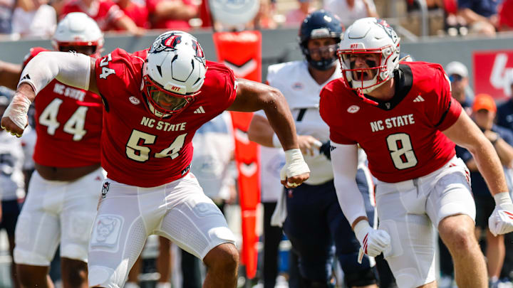 Sep 6, 2025; Raleigh, North Carolina, USA; North Carolina State Wolfpack defensive end Sabastian Harsh (54) celebrates a tackle against Virginia Cavaliers running back J'Mari Taylor (3) during the first half of the game at Carter-Finley Stadium. Mandatory Credit: Jaylynn Nash-Imagn Images