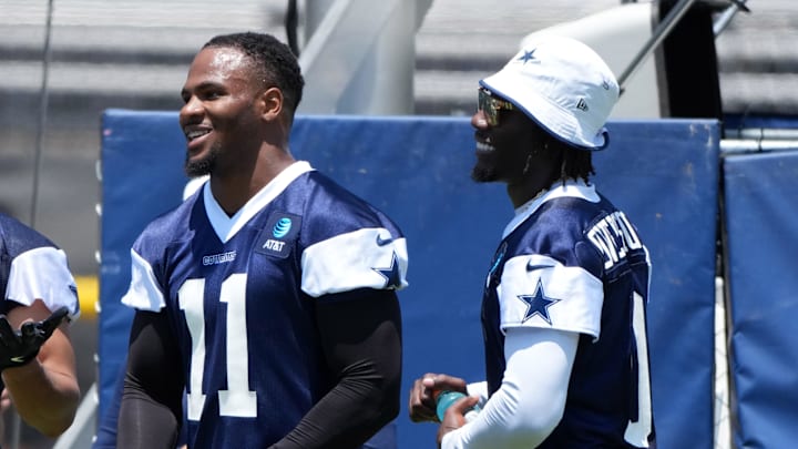Dallas Cowboys stars Micah Parsons and DeMarvion Overshown laugh on the sideline during training camp practice in Oxnard.