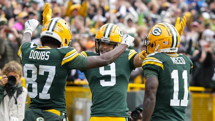 Oct 13, 2024; Green Bay, Wisconsin, USA;  Green Bay Packers wide receiver Romeo Doubs (87) celebrates with wide receivers Christian Watson (9) and Jayden Reed (11) after scoring a touchdown during the third quarter against the Arizona Cardinals at Lambeau Field. Mandatory Credit: Jeff Hanisch-Imagn Images