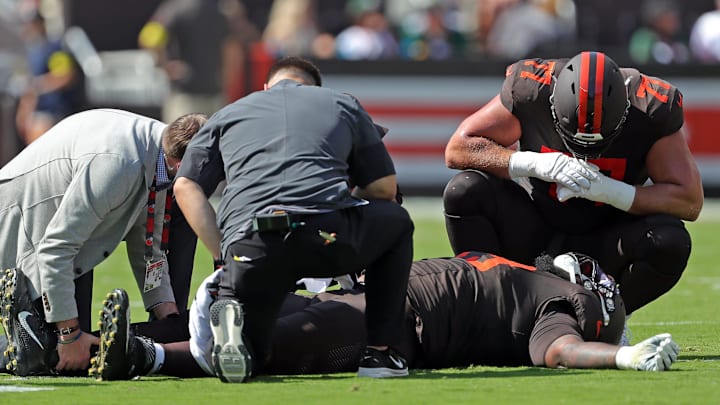 Cleveland Browns medical staff and guard Wyatt Teller (77) check on offensive tackle Dawand Jones after he was injured in a game against the Green Bay Packers on Sept. 21, 2025, in Cleveland.