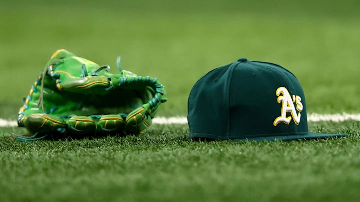 Jul 22, 2025; Arlington, Texas, USA;  Athletics glove and hat on the field before the game against the Texas Rangers at Globe Life Field. Mandatory Credit: Kevin Jairaj-Imagn Images